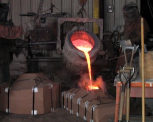  The figure shows molten silicon bronze being used in a sand casting procedure.