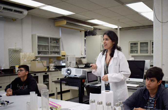 Adriana Santiago-Ruiz (Middle): Explaining details of the materials science experiment to the high school participants at “Experimenta con PREM”