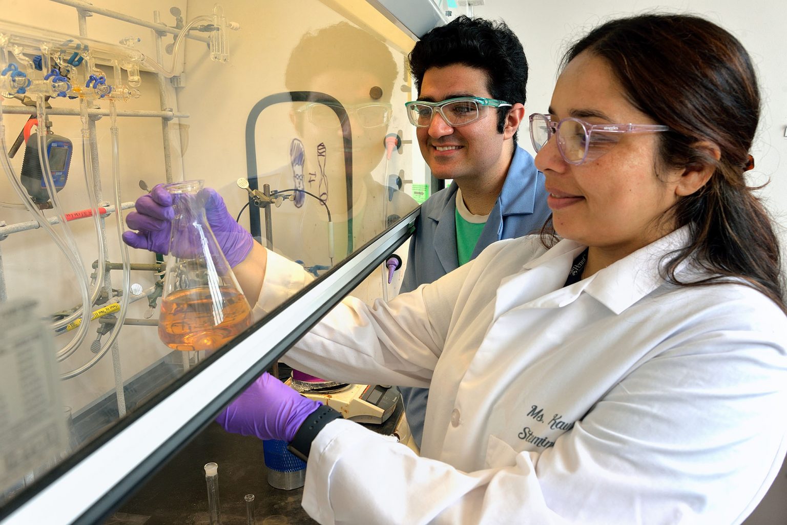 Image of RET teacher hands on in the lab with a graduate student mentor