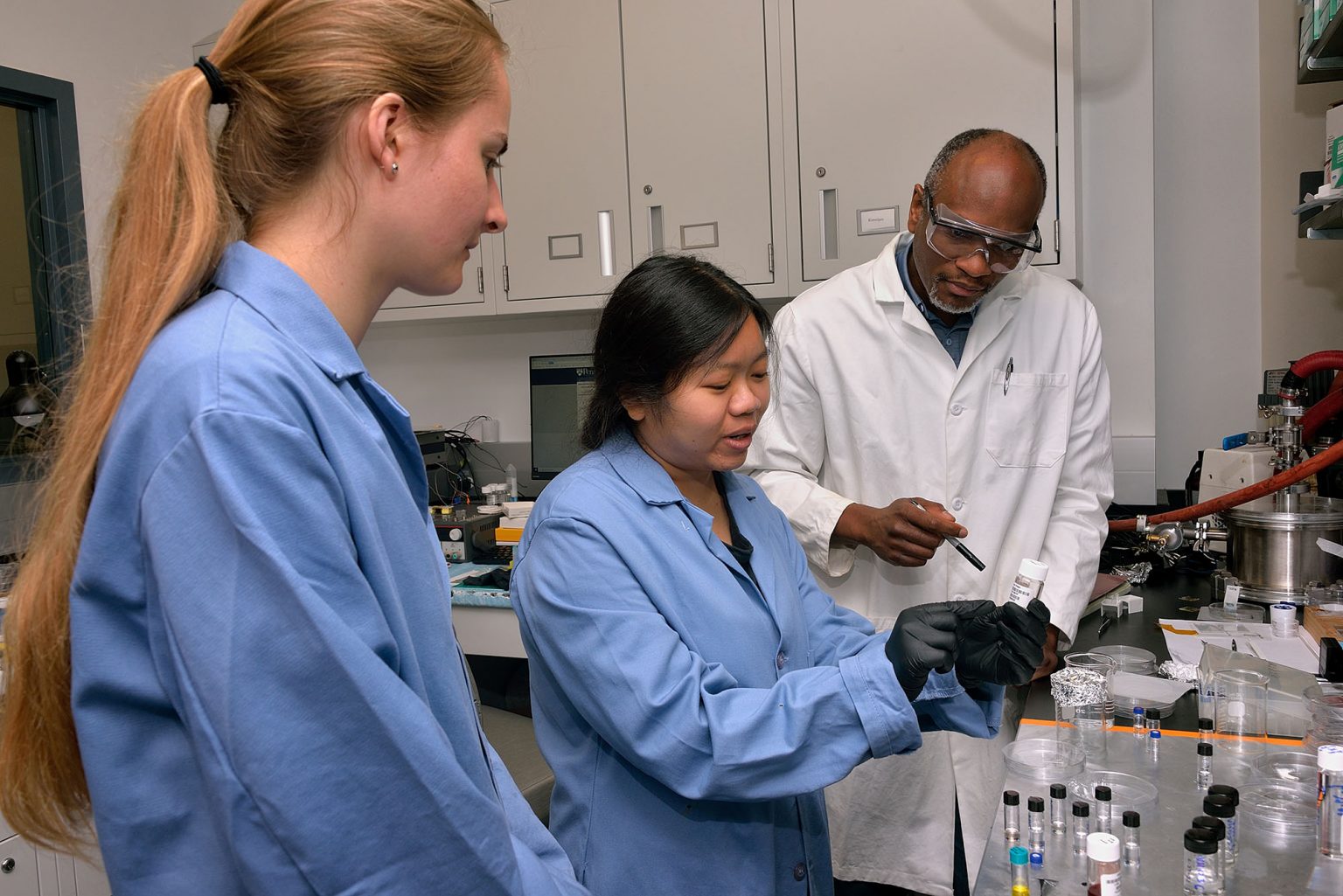Image of REU students with Chinedum Osuji in the lab