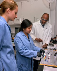 Image of REU students with Chinedum Osuji in the lab